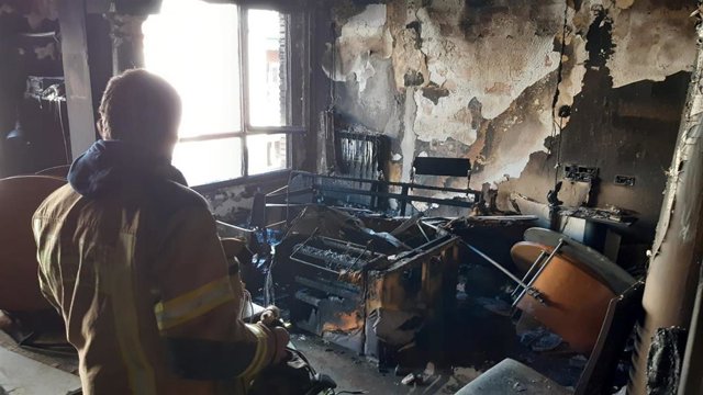 Un bombero trabaja en las labores de extinción del incendio que se ha producido en el número 11 de la calle Labradores de Logroño