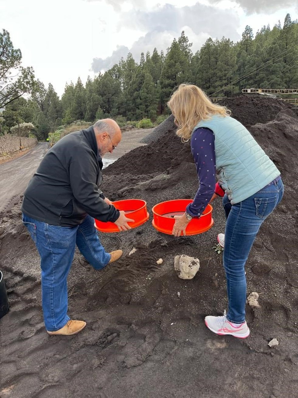 Dos personas recogen muestras de ceniza del volcán de Cumbre Vieja