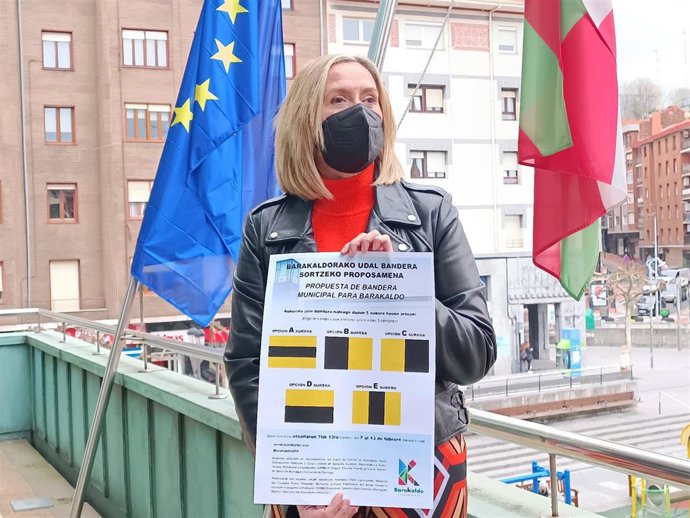 La alcaldesa, Amaia del Campo, muestra el cartel con las cinco banderas entre las que tendrán que elegir los vecinos.