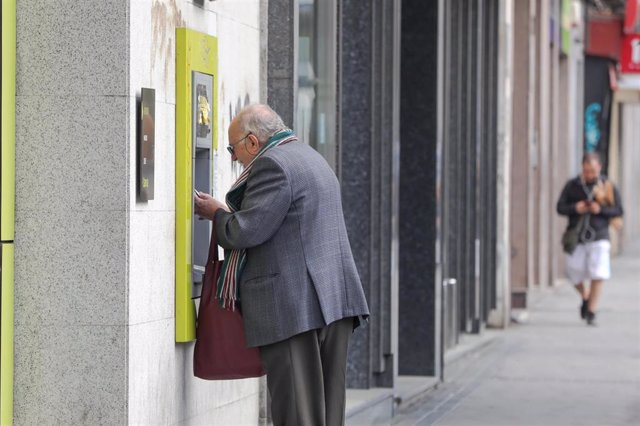 Archivo - Un anciano saca dinero de un cajero de la capital tras el anuncio del Estado de Alarma y las restricciones impuestas para evitar la expansión del coronavirus por el país, en Madrid (España), a 15 de marzo de 2020.