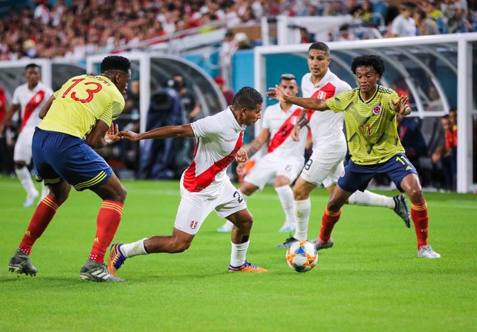 Archivo - 15 November 2019, US, Miami Gardens: Peru's Edison Flores (C) battles for the ball with Colombia's Juan Cuadrados (R) and Yerry Mina (L) during the international friendly soccer match between Colombia and Peru at the Hard Rock Stadium. Photo: 