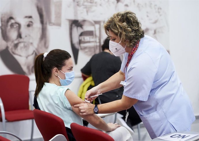 Archivo - Un trabajadora sanitaria inyecta la segunda dosis de la vacuna de Pfizer.- Archivo