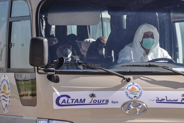 Archivo - 03 February 2020, Algeria, Algiers: Passengers, from Algeria, Libya and Mauritania, wearing surgical masks, leave on a transport bus at the the Houari Boumediene Airport, after arriving on an Algerian air plane following their evacuation from Ch