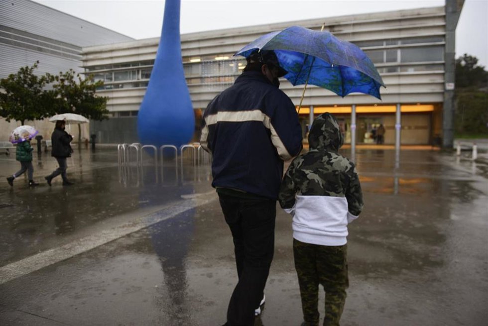 Un niño acompañado de su padre, a su llegada al recinto ferial Expourense para ser vacunado, el día en el que han reanudado el proceso de vacunación infantil, a 4 de enero de 2022, en Ourense