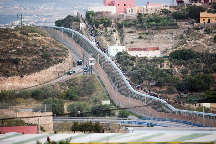 Archivo - Varios marroquíes intentan llegar a suelo español desde la frontera que separa Melilla y Marruecos, a 21 de mayo de 2021