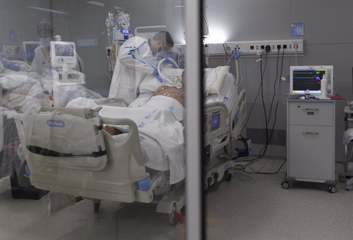 Un sanitario alrededor de un paciente ingresado en la UCI del Hospital Enfermera Isabel Zendal, a 13 de enero de 2022, en Madrid (España). La incidencia acumulada a 14 días en la Comunidad de Madrid ha subido 87,35 puntos, hasta situarse en 2.528,84 cas