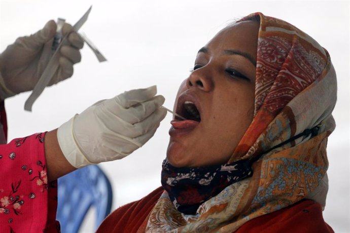 26 January 2022, Bangladesh, Dhaka: A health worker collects a nasal swab sample of a woman to test for Coronavirus (Covid-19) at Mugda Medical University Hospital. Photo: Habibur Rahman/ZUMA Press Wire Service/dpa