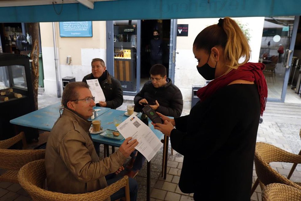 Archivo - Una camarera pide certificado a los clientes en una mesa en la terraza de un bar