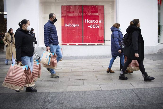 Varias personas con bolsas pasean en una calle comercial del centro de Madrid, a 2 de enero de 2022, en Madrid, (España). Comienzan las rebajas de enero que generarán un 14 % más de empleo, sobre todo en logística, respecto a 2021. Aunque las rebajas co