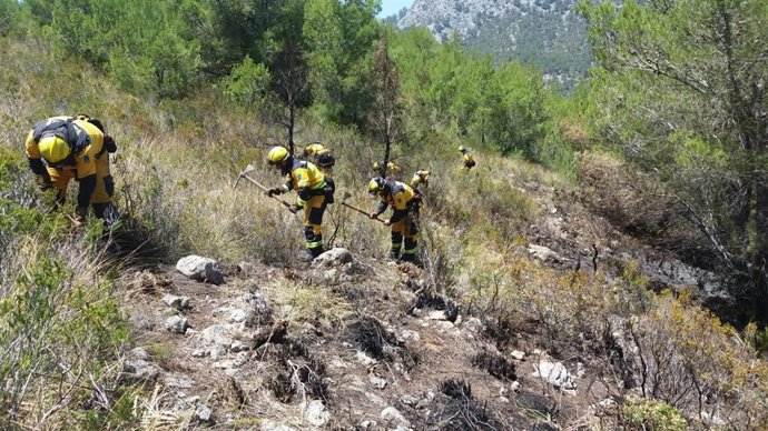 Archivo - Técnicos de medio ambiente actúan en la extinción de un incendio forestal. Archivo.
