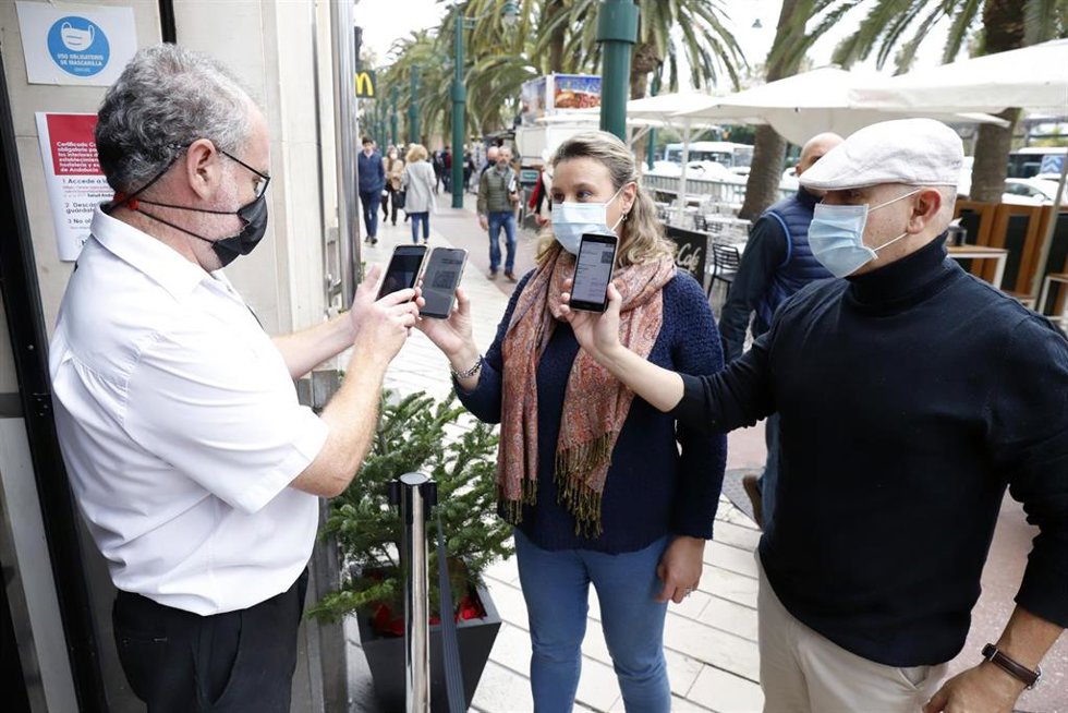 Archivo - Un camarero pide certificado a los clientes en la puerta de un bar durante el primer día de petición de Certificados Covid-19. 