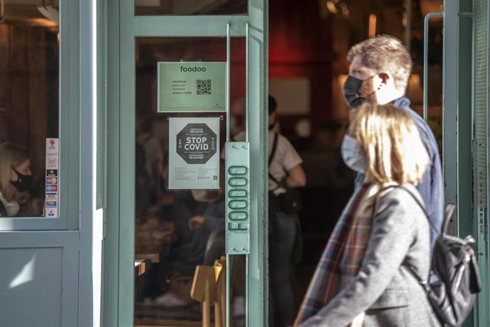 Archivo - Un local muestra en su puerta la exigencia de mostrar el pasaporte covid 