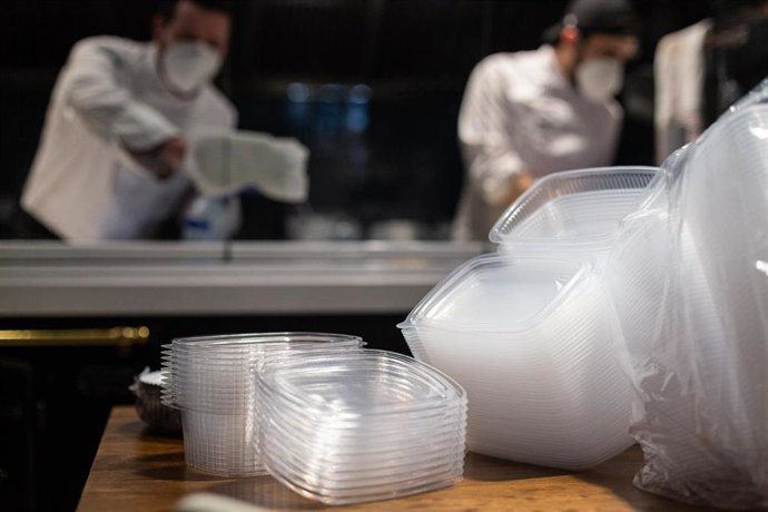 Archivo - Dos cocineros preparan un plato en un restaurante 
