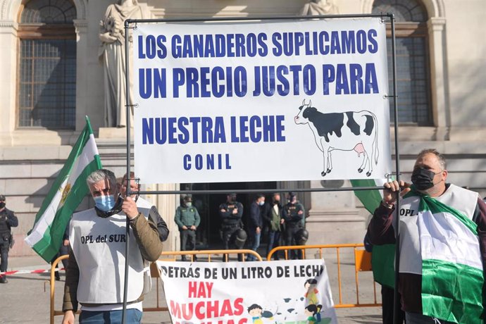 Dos ganaderos de la organización OPL del Sur portan una pancarta en la que reclaman un precio justo para la leche, en una concentración frente al Ministerio de Agricultura, Pesca y Alimentación