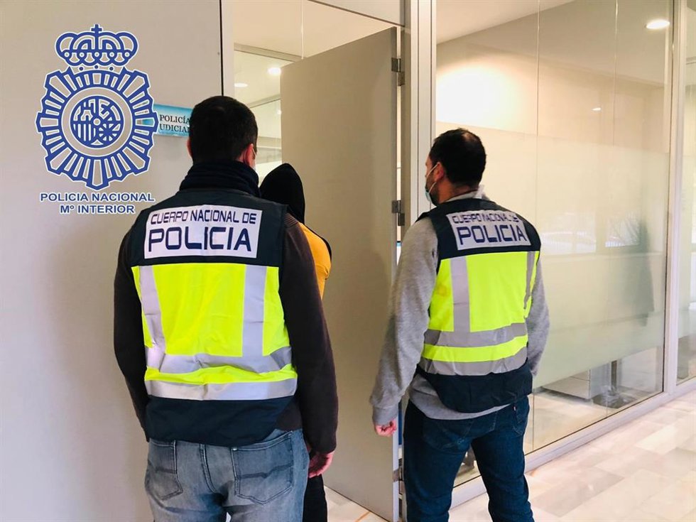 Agentes conduciendo al detenido