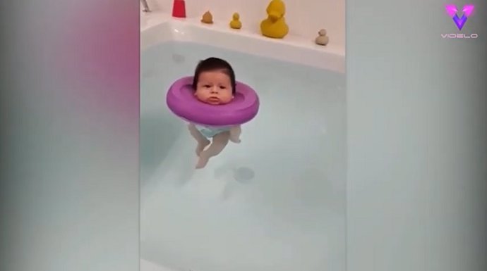 Divertido bebé con un flotador en la cabeza