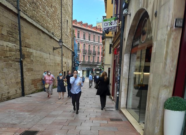 Personas con mascarilla en las calles de Oviedo y terrazas de hostelería.