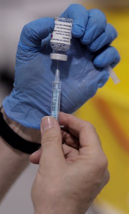 Archivo - Un sanitario sostiene una vacuna contra el Covid-19