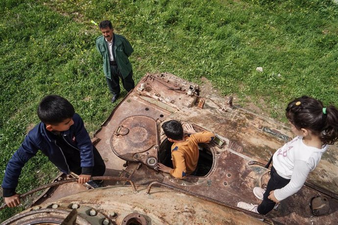Archivo - Niños iraquíes jugando en un tanque de guerra abandonado