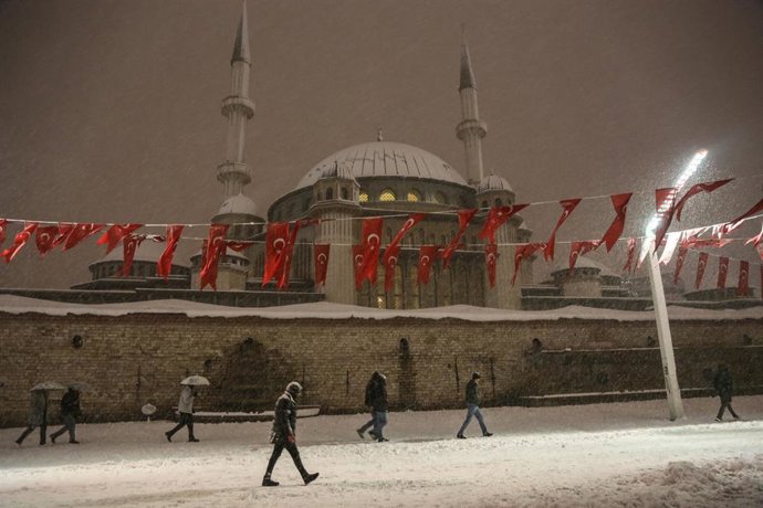 25 January 2022, Turkey, Istanbul: People walk in Taksim Square in front of Taksim Mosque during the heavy snowfall. Photo: Hakan Akgun/SOPA Images via ZUMA Press Wire/dpa