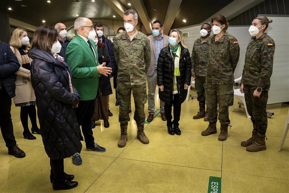 La ministra de Defensa, Margarita Robles, acompañada del consejero de Sanidad, Miguel Rodríguez, saludad al equipo del Ejército de Tierra que realiza labores de vacunación en el punto instalado en el Palacio de Deportes de Santander