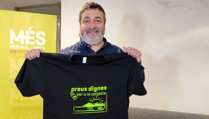 El diputado de MÉS, Joan Mas, sostiene una camiseta reclamando precios dignos para los agricultores.