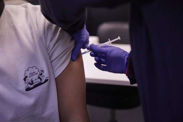 Detalle de una persona, de entre 18 y 29 años, recibiendo  la tercera dosis de la vacuna contra el Covid-19