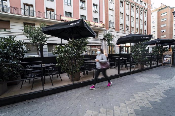 Una mujer pasa por una terraza en la calle de Gaztambide, el mismo día en que ha entrado en vigor la modificada ordenanza de Terrazas de Madrid, en la calle de Ponzano, a 1 de febrero de 2022, en Madrid (España). Desde hoy, debido a esta modificación, u