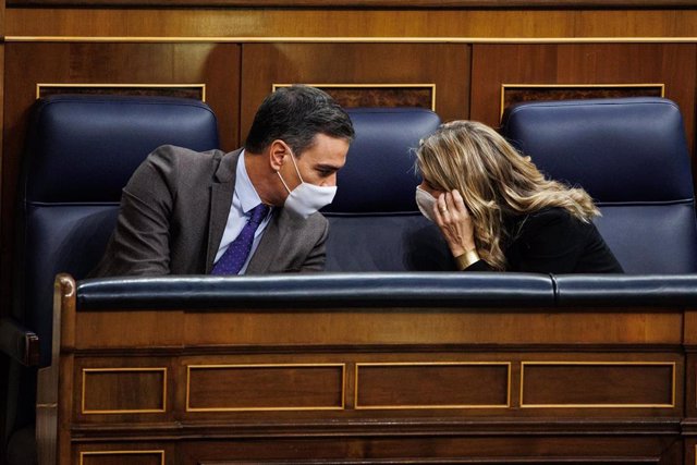 El presidente del Gobierno, Pedro Sánchez y la vicepresidenta segunda y ministra de Trabajo y Economía Social, Yolanda Díaz, mantienen una conversación en una sesión plenaria en el Congreso de los Diputados, a 3 de febrero de 2022, en Madrid (España). 