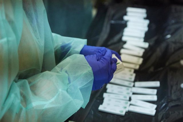 Una enfermera abre un test de antígeno para realizarle la prueba a un costalero durante el primer ensayo de costaleros de la Hermandad del Baratillo, con medidas covid-19, preparatorio a la Semana Santa de 2022, a 2 de febrero de 2022 en Sevilla (Andalucí