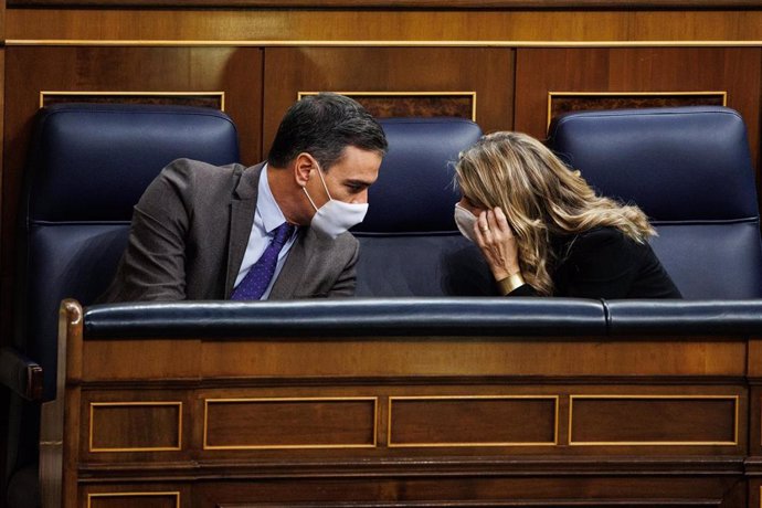 El presidente del Gobierno, Pedro Sánchez y la vicepresidenta segunda y ministra de Trabajo y Economía Social, Yolanda Díaz, mantienen una conversación en una sesión plenaria en el Congreso de los Diputados, a 3 de febrero de 2022, en Madrid (España).