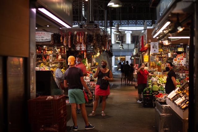Una mujer hace una foto a un joven en el mercado de La Boquería, a 5 de agosto de 2021, en Barcelona, Cataluña, (España).