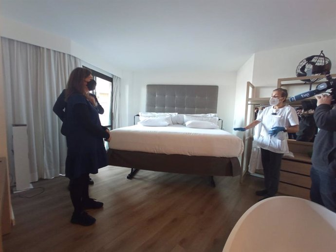 La presidenta del Govern, Francina Armengol, atiende a la explicación de una trabajadora del hotel.