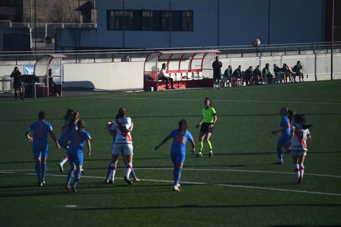 Un partido del Rayo Vallecano femenino con su entrenador, Carlos Santiso, al fondo
