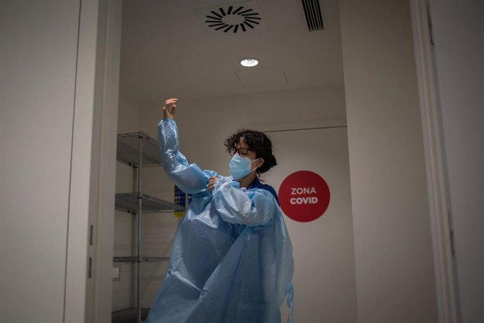 Archivo - Una profesional sanitaria se viste con un Equipo de Protección Individual (EPI) 