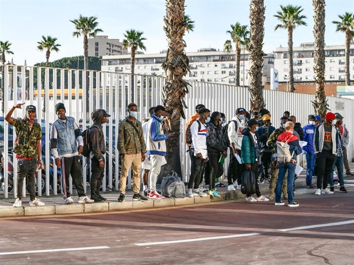 Un grupo de migrantes hacen cola en el Puerto de Ceuta
