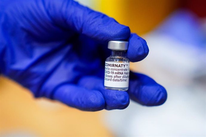 Archivo - Un empleado sanitario muestra una dosis de la vacuna de Pfizer-BioNTech contra el Covid-19
