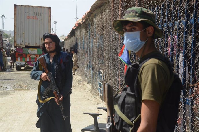 Un milici talib i un militar pakistans a la frontera entre l'Afganistan i el Pakistan