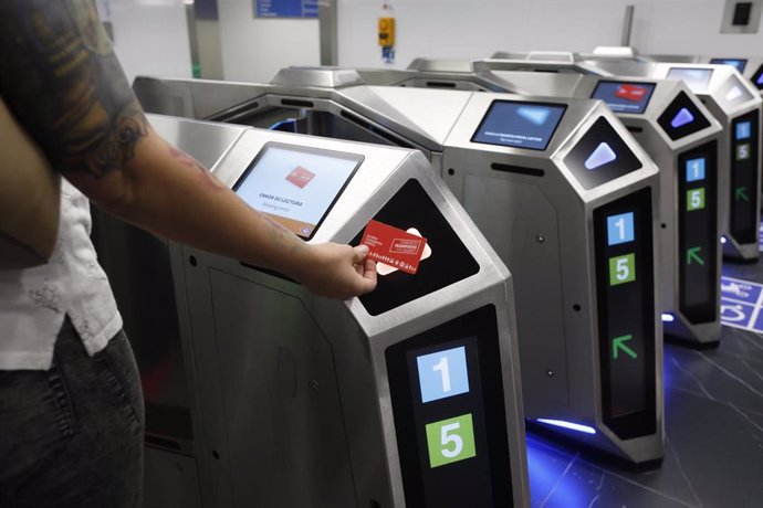 Archivo - Un viajero valida su billete en la estación de Metro de Gran Vía .