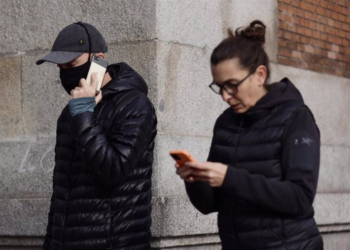 Un hombre camina con mascarilla y una mujer sin mascarilla, a 4 de febrero de 2022, en Madrid (España). El Gobierno, en Consejo de Ministros, eliminará el uso de las mascarillas en exteriores el próximo martes, 8 de febrero, y la medida entrará en vigor