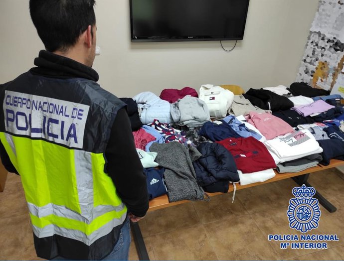 Un agente junto a las prendas aprehendidas