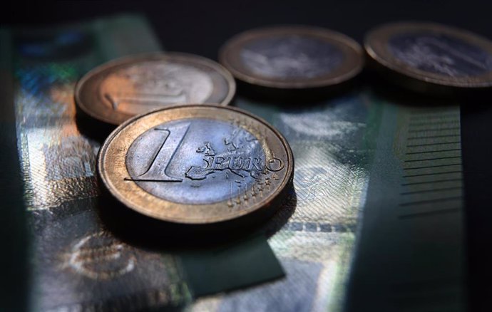 Archivo - FILED - 27 May 2021, Bavaria, Augsburg: One-euro coins and 100-euro banknotes lie on a table. German banks have been told to strengthen their financial safety nets due to increasing risks in global markets, the financial authorities in Europe'