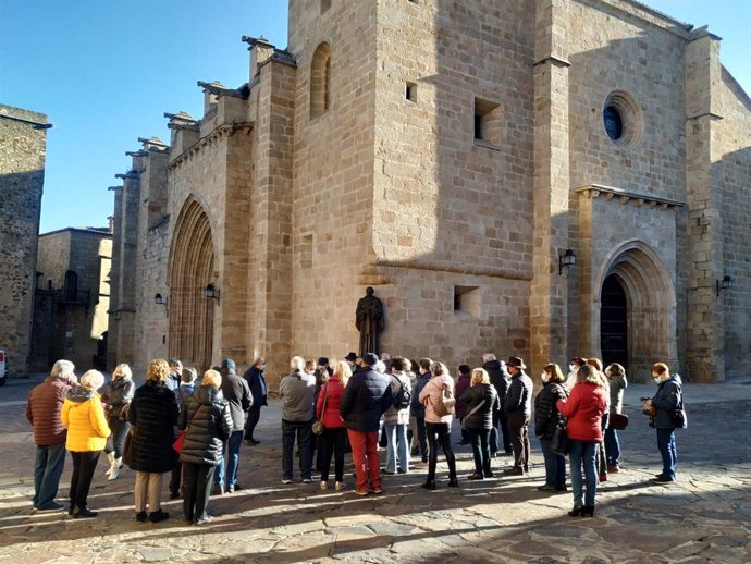Archivo - Turistas en una visita guiada a la parte antigua de Cáceres