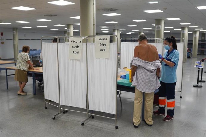 Archivo - Una `persona se vacuna con la tercera dosis Covid y la vacuna de la gripe, foto de archivo