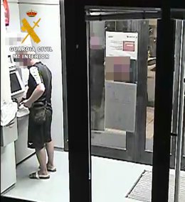 Uno de los arrestados saca dinero de un cajero