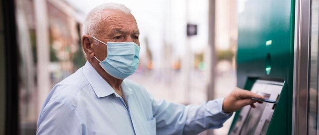 Una persona mayor hace uso de un cajero