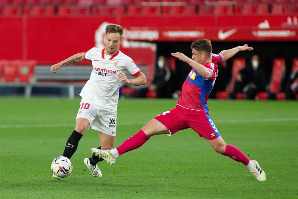 Archivo - El jugador del Sevilla Ivan Rakitic intenta regatear al futbolista del Elche Raul Guti durante un partido en el Ramón Sánchez-Pizjuán de LaLiga Santander 2021-2022.