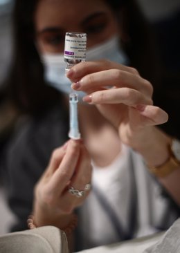 Archivo - Una profesional sanitaria sostiene una jeringuilla con un vial de la vacuna contra el Covid-19