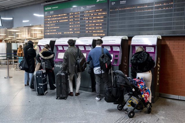 Archivo - Varias personas sacando un billete de AVE en la Estación de Atocha (Madrid)