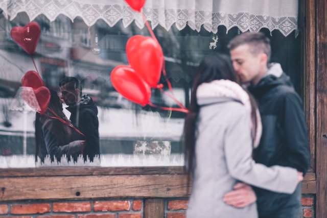 Dos personas se besan delante de un restaurante
